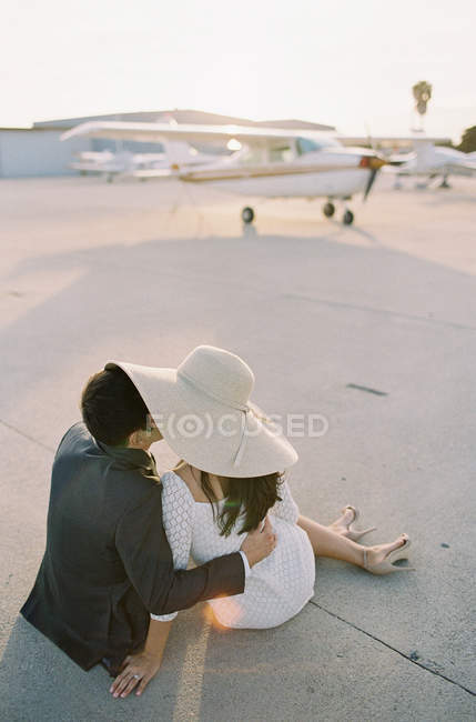 Couple sitting on ground and kissing — Stock Photo