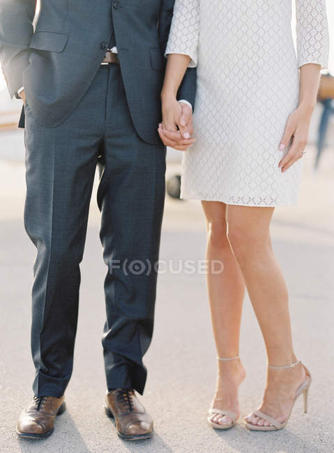 Couple standing hand in hand at airfield — Stock Photo