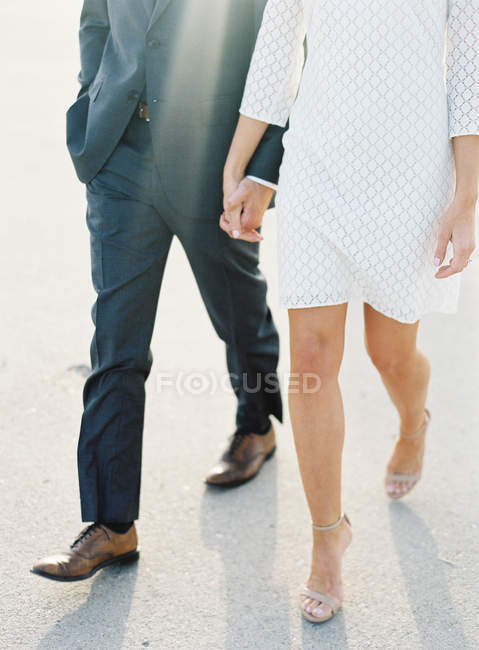 Couple walking hand in hand at airfield — Stock Photo