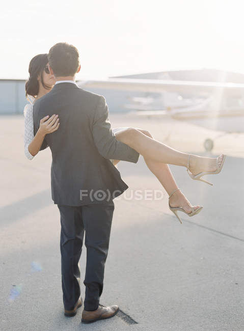 Homme tenant femme sur les mains — Photo de stock
