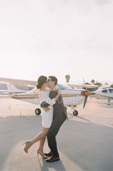 Casal apaixonadamente beijando no aeródromo — Fotografia de Stock
