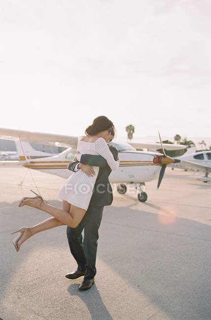 Мужчина поднимает женщину с земли и целует — стоковое фото