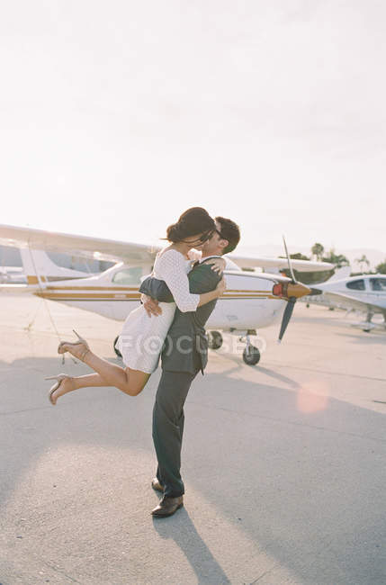 Мужчина поднимает женщину с земли и целует — стоковое фото