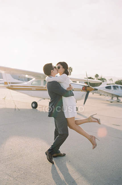 Man lifting woman from ground and kissing — Stock Photo