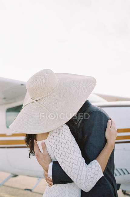 Couple hugging and kissing at airfield — Stock Photo