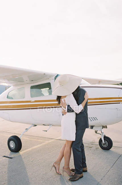 Paar umarmt und küsst sich am Flugplatz — Stockfoto