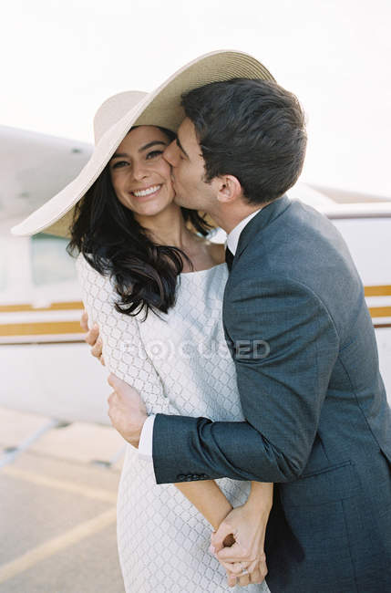 Чоловік обіймає і цілує жінку на аеродромі — стокове фото