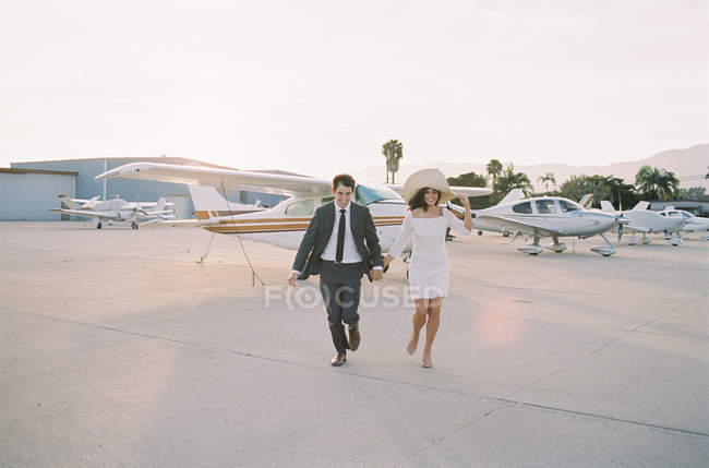 Couple walking away from plane — Stock Photo