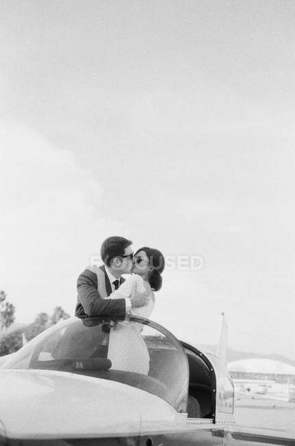 Пара целуется в кабине самолета — стоковое фото