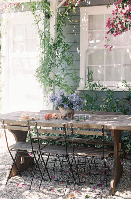 Maçãs e flores na mesa de madeira rústica — Fotografia de Stock