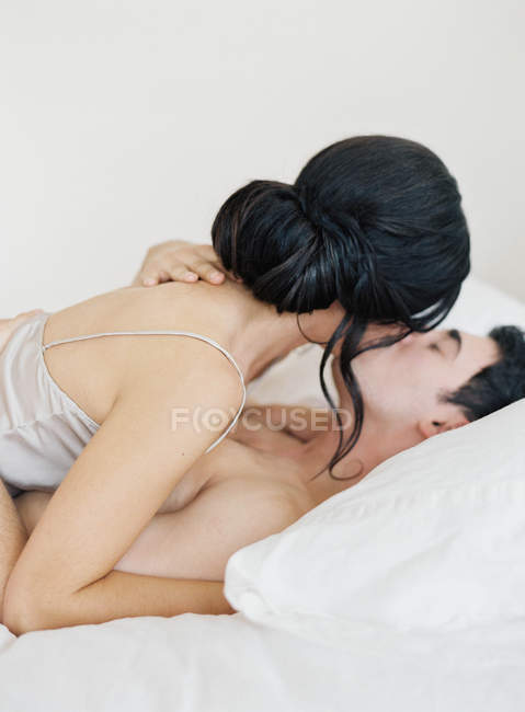 Donna sdraiata su uomo e baci — Foto stock