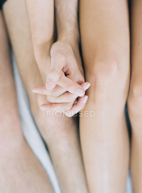 Casal de mãos dadas enquanto deitado na cama — Fotografia de Stock