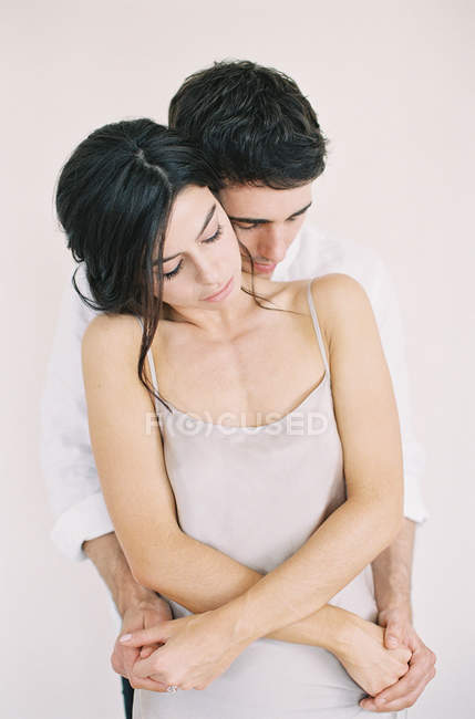 Hombre abrazando a mujer y tomándose de la mano - foto de stock