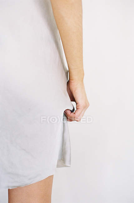 Female hand pulling dress up — Stock Photo