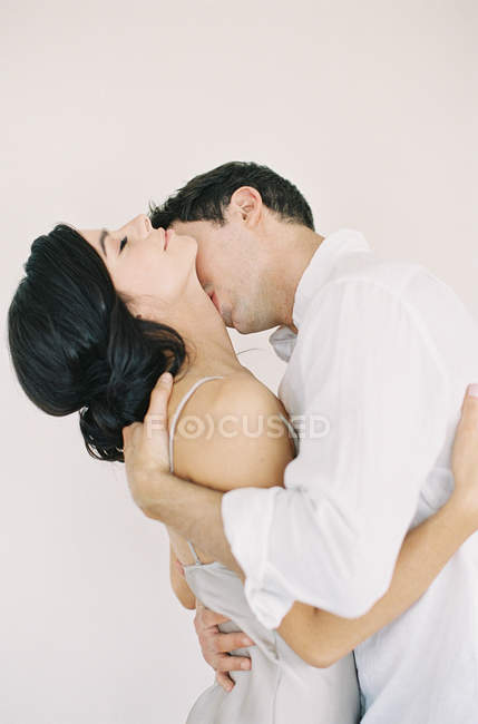 Мужчина обнимает и целует женщину — стоковое фото