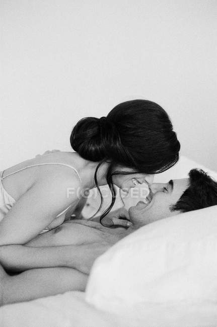 Donna sdraiata su un uomo a letto — Foto stock