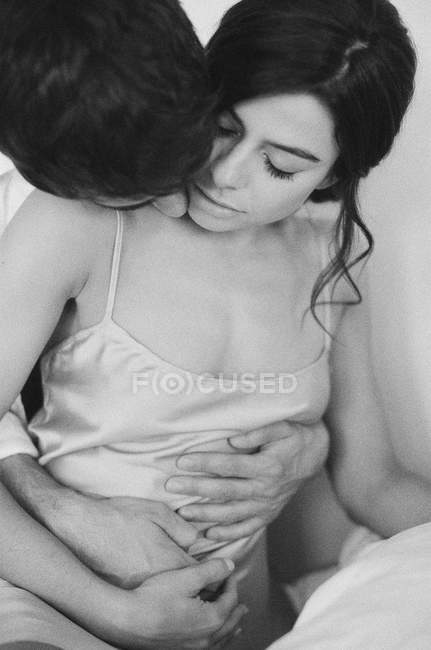 Чоловік цілує жінку, обіймаючи — стокове фото