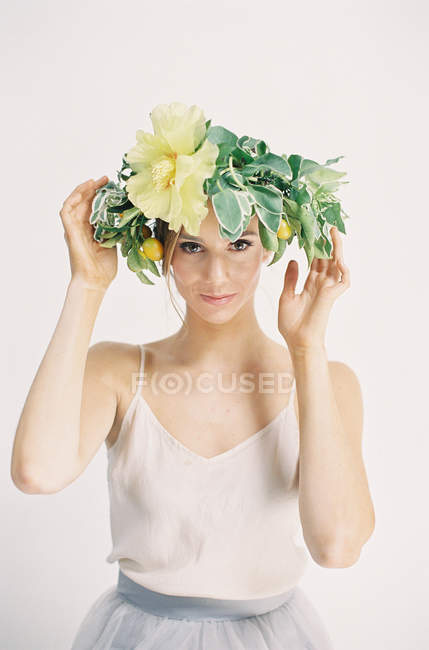 Mujer ajustando corona de flores - foto de stock