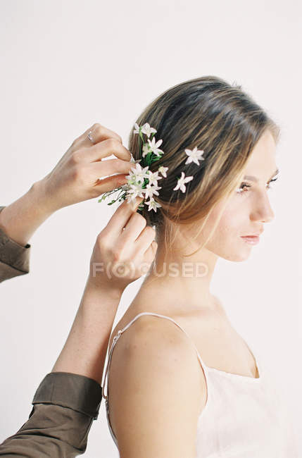 Estilista agregando flores al cabello - foto de stock