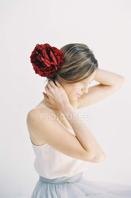 Frau mit roten Blumen im Haar — Stockfoto