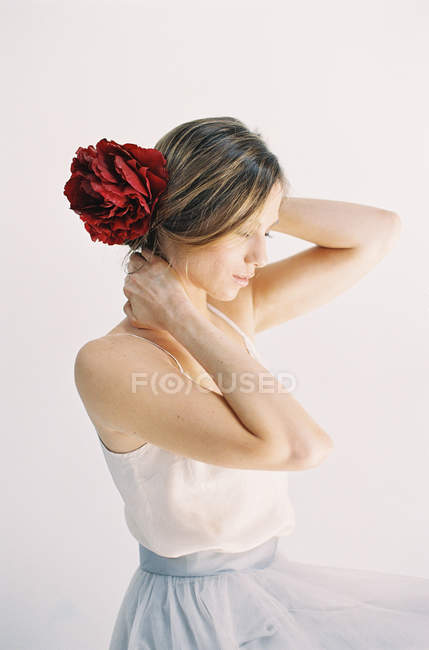 Mujer con flores rojas en el pelo - foto de stock