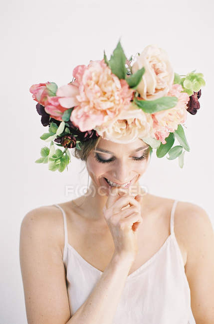 Femme en couronne de fleur doigt mordant — Photo de stock