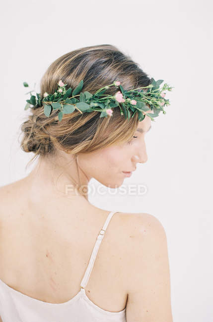 Mujer con corona floral mirando hacia otro lado - foto de stock