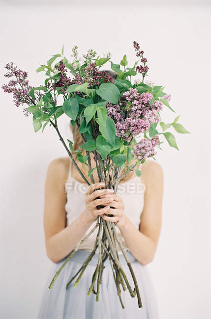 Frau im Tüllkleid mit fliederfarbenen Blumen — Stockfoto