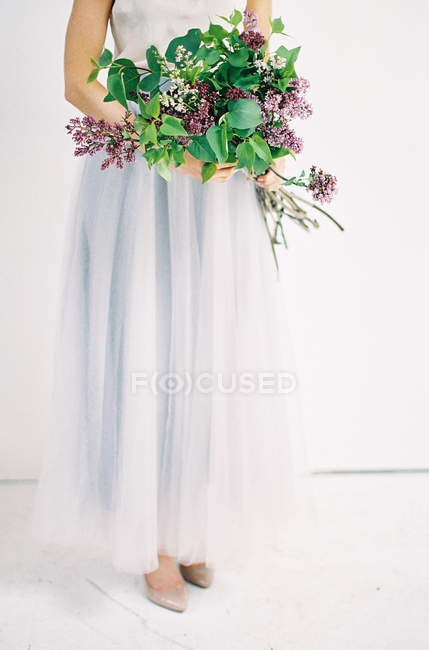 Frau im Tüllkleid mit Blumenstrauß — Stockfoto