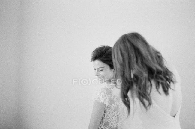 Woman helping bride with wedding dress — Stock Photo