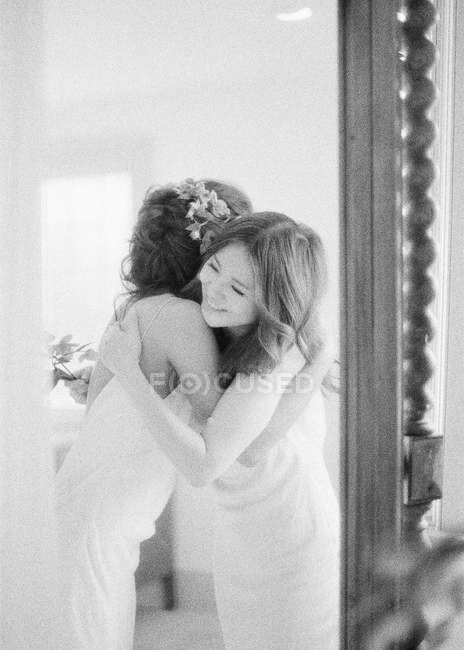 Woman in wedding dress hugging friend — Stock Photo