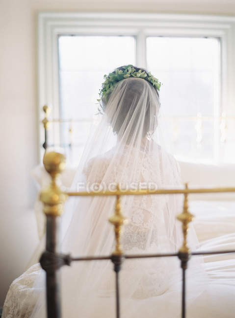 Frauen im Hochzeitskleid sitzen auf dem Bett — Stockfoto