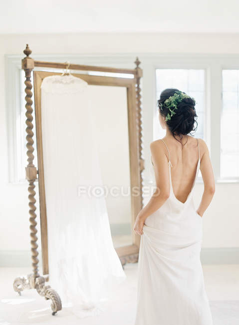 Donna in tulle vestito guardando ta specchio — Foto stock