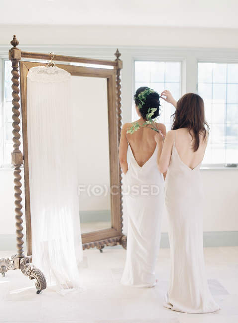 Mujer ayudando novia con la decoración del cabello - foto de stock
