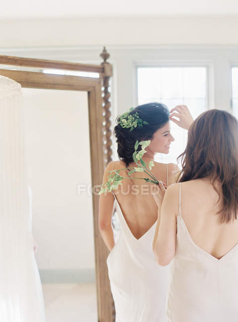 Donna che aiuta sposa con la decorazione dei capelli — Foto stock