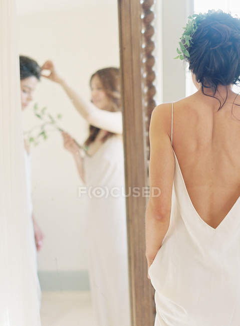 Женщина помогает невесте с украшением волос — стоковое фото
