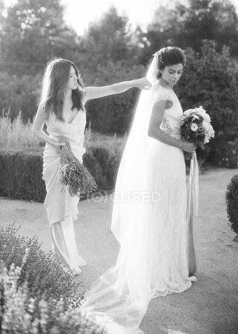 Mulher ajudando noiva com véu — Fotografia de Stock