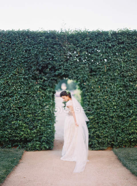 Femme en robe de mariée fixant voile — Photo de stock