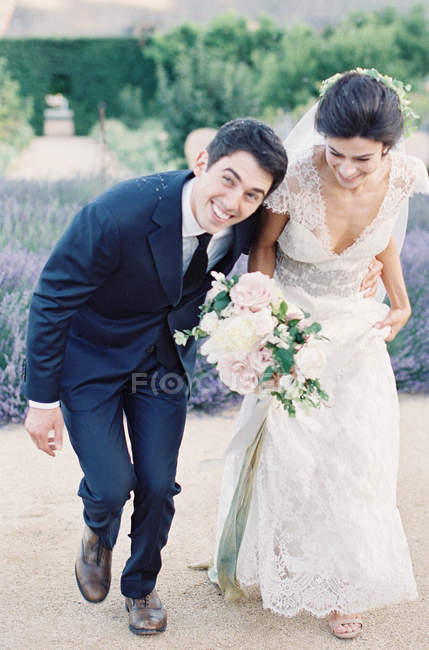 Heureux jeunes mariés main courante — Photo de stock