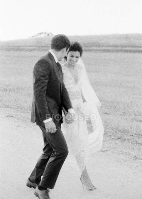 Молодая супружеская пара, гуляющая в поле — стоковое фото