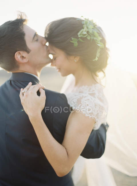 Sposo holding e baciare sposa — Foto stock