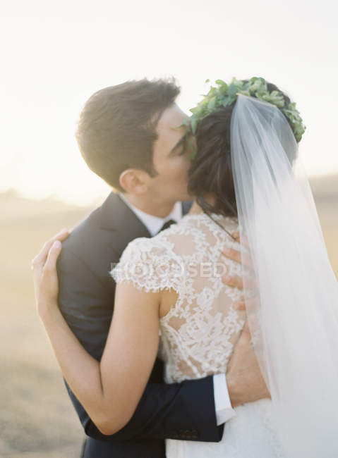 Recém-casados abraçando ao ar livre — Fotografia de Stock