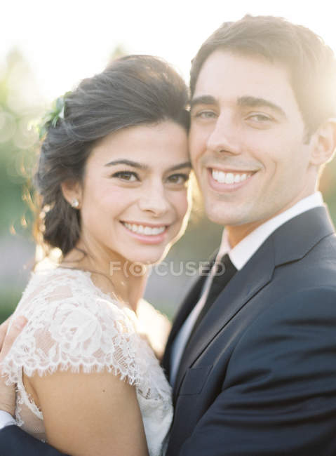 Frisch vermähltes Paar umarmt und lächelt — Stockfoto