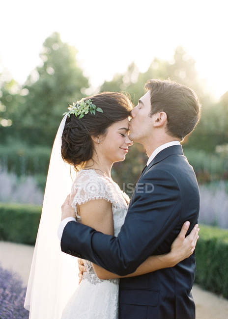 Groom hugging and kissing bride — Stock Photo