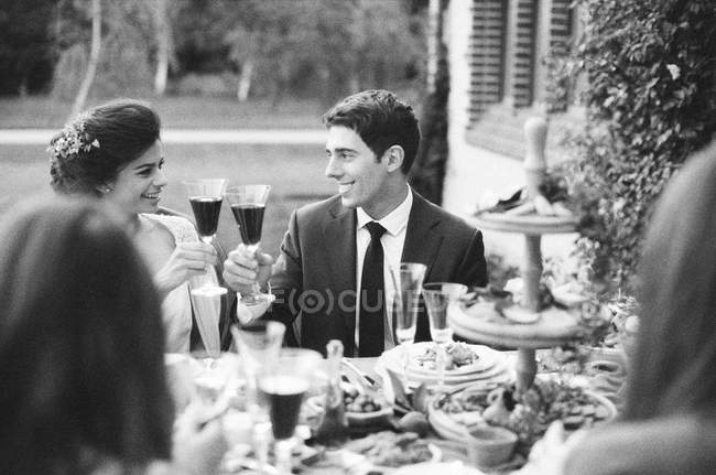Groom and bride toasting red wine — Stock Photo