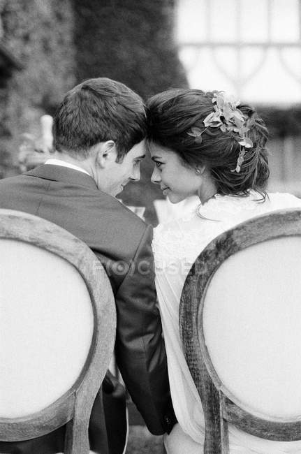 Sposo e sposa seduta testa a testa — Foto stock