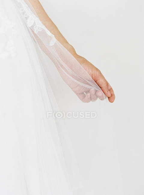 Mão feminina segurando véu de casamento — Fotografia de Stock