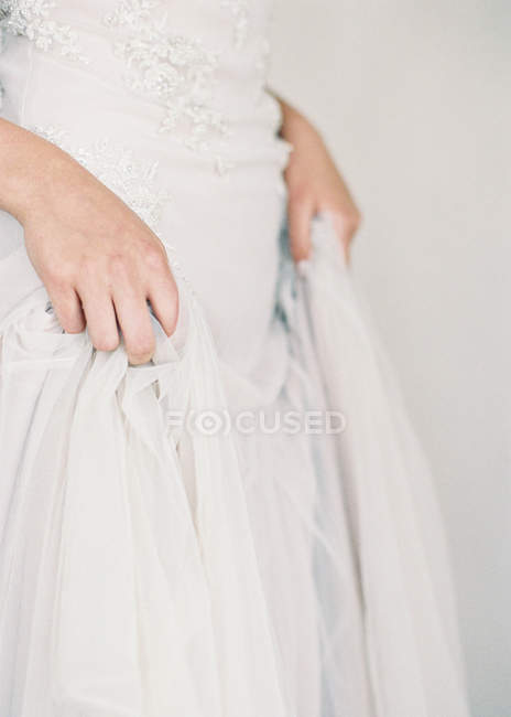 Donna mani tirando su abito da sposa — Foto stock