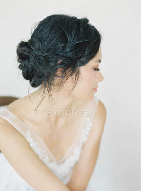 Woman in bridal gown sitting on chair — Stock Photo