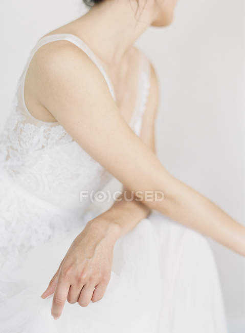 Женщина в свадебном платье сидит на стуле — стоковое фото
